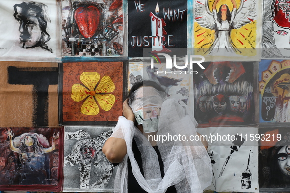 An Indian artist performs as she protests during a rally against the rape and murder of a PGT woman doctor at the government-run R G Kar Med...