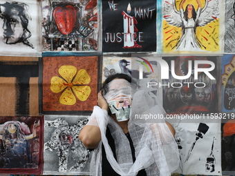 An Indian artist performs as she protests during a rally against the rape and murder of a PGT woman doctor at the government-run R G Kar Med...