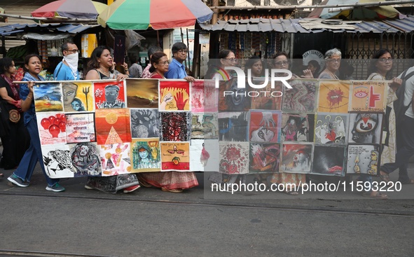 Indian artists protest with their paintings while they shout slogans during a protest rally against the rape and murder of a PGT woman docto...