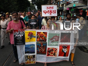 Indian artists protest with their paintings while they shout slogans during a protest rally against the rape and murder of a PGT woman docto...