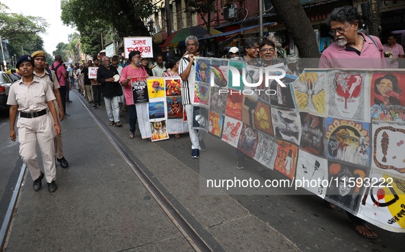 Indian artists protest with their paintings while they shout slogans during a protest rally against the rape and murder of a PGT woman docto...