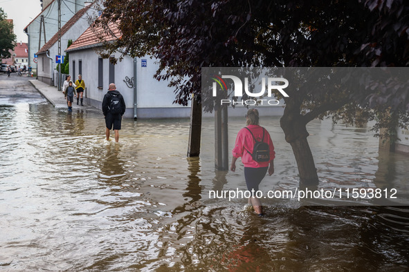 Residents walk in the water after Nysa Klodzka river flooded town of Lewin Brzeski in southwestern Poland, on September 19th, 2024. Storm Bo...