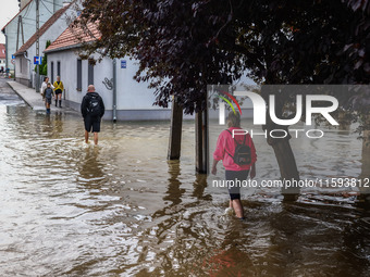 Residents walk in the water after Nysa Klodzka river flooded town of Lewin Brzeski in southwestern Poland, on September 19th, 2024. Storm Bo...