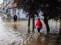 Residents walk in the water after Nysa Klodzka river flooded town of Lewin Brzeski in southwestern Poland, on September 19th, 2024. Storm Bo...