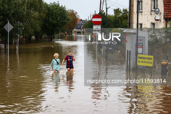 Children walk in the water after Nysa Klodzka river flooded town of Lewin Brzeski in southwestern Poland, on September 19th, 2024. Storm Bor...