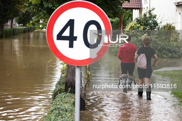 Residents walk in the water after Nysa Klodzka river flooded town of Lewin Brzeski in southwestern Poland, on September 19th, 2024. Storm Bo...