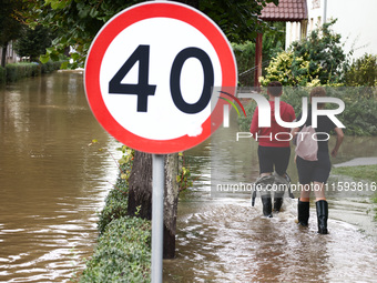 Residents walk in the water after Nysa Klodzka river flooded town of Lewin Brzeski in southwestern Poland, on September 19th, 2024. Storm Bo...