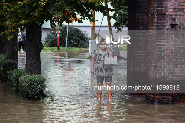 A woman walks in the water after Nysa Klodzka river flooded town of Lewin Brzeski in southwestern Poland, on September 19th, 2024. Storm Bor...