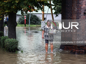 A woman walks in the water after Nysa Klodzka river flooded town of Lewin Brzeski in southwestern Poland, on September 19th, 2024. Storm Bor...