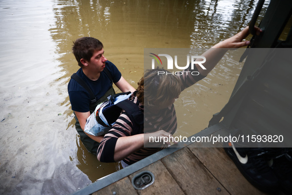 A woman walks into the water to reach her hoase after Nysa Klodzka river flooded town of Lewin Brzeski in southwestern Poland, on September...