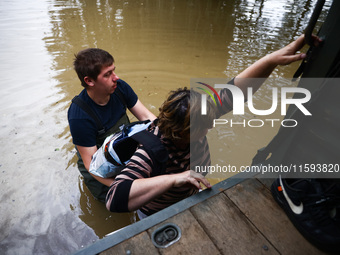 A woman walks into the water to reach her hoase after Nysa Klodzka river flooded town of Lewin Brzeski in southwestern Poland, on September...