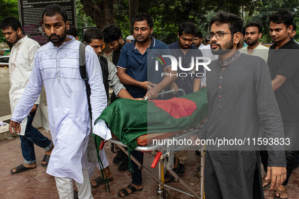 People carry the body of Nayon Mia (25), who dies 48 days after being shot during the Anti-discrimination Student Movement, to perform his f...