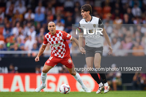 Javi Guerra of Valencia CF competes for the ball with Oriol Romeu of Girona FC during the LaLiga EA Sports match between Valencia CF and Gir...