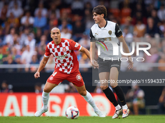 Javi Guerra of Valencia CF competes for the ball with Oriol Romeu of Girona FC during the LaLiga EA Sports match between Valencia CF and Gir...