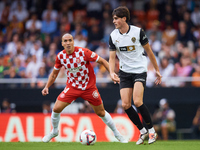 Javi Guerra of Valencia CF competes for the ball with Oriol Romeu of Girona FC during the LaLiga EA Sports match between Valencia CF and Gir...