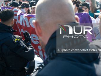 Police approach the dozen counter-protesters who block the street as thousands of people take part in the annual pro-life demonstration orga...