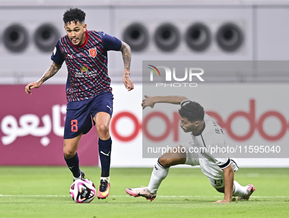 Abdulla Badr Alyazidi (R) of Al-Sadd SC battles for the ball with Edmilson Junior Paulo (L) of Duhail SC during the Ooredoo Qatar Stars Leag...