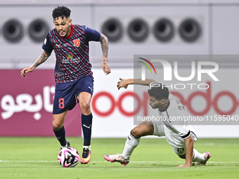 Abdulla Badr Alyazidi (R) of Al-Sadd SC battles for the ball with Edmilson Junior Paulo (L) of Duhail SC during the Ooredoo Qatar Stars Leag...