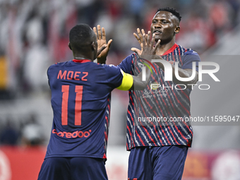 Michael Olunga (R) of Al Duhail SC celebrates after scoring a goal during the Ooredoo Qatar Stars League 24/25 match between Al-Sadd SC and...