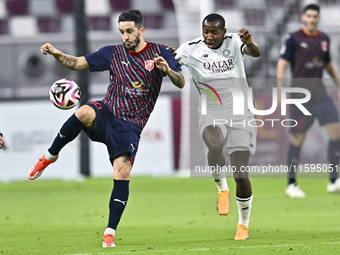 Mohamed Camara (R) of Al-Sadd SC battles for the ball with Luis Alberto (L) of Duhail SC during the Ooredoo Qatar Stars League 24/25 match b...