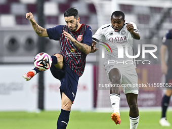 Mohamed Camara (R) of Al-Sadd SC battles for the ball with Luis Alberto (L) of Duhail SC during the Ooredoo Qatar Stars League 24/25 match b...