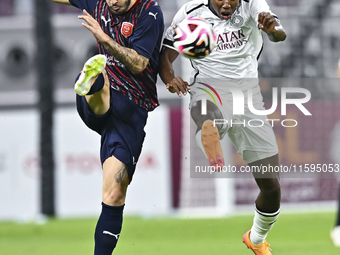 Mohamed Camara (R) of Al-Sadd SC battles for the ball with Luis Alberto (L) of Duhail SC during the Ooredoo Qatar Stars League 24/25 match b...