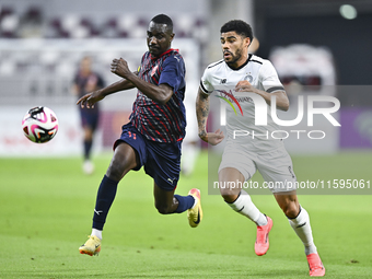 Paulo Silva (R) of Al-Sadd SC battles for the ball with Almoez Abdulla (L) of Duhail SC during the Ooredoo Qatar Stars League 24/25 match be...