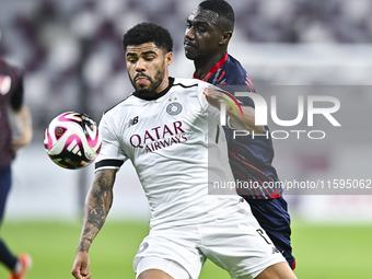 Paulo Silva (L) of Al-Sadd SC battles for the ball with Almoez Abdulla (R) of Duhail SC during the Ooredoo Qatar Stars League 24/25 match be...