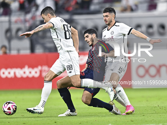 Rafael Sebastian Mujica Garcia of Al-Sadd SC battles for the ball with Karim Buddaif of Duhail SC during the Ooredoo Qatar Stars League 24/2...