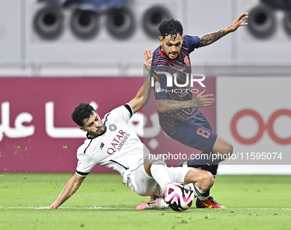 Abdulla Badr Alyazidi (L) of Al-Sadd SC battles for the ball with Edmilson Junior Paulo (R) of Duhail SC during the Ooredoo Qatar Stars Leag...