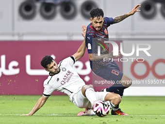 Abdulla Badr Alyazidi (L) of Al-Sadd SC battles for the ball with Edmilson Junior Paulo (R) of Duhail SC during the Ooredoo Qatar Stars Leag...