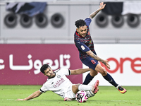 Abdulla Badr Alyazidi (L) of Al-Sadd SC battles for the ball with Edmilson Junior Paulo (R) of Duhail SC during the Ooredoo Qatar Stars Leag...