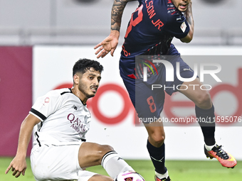 Abdulla Badr Alyazidi (L) of Al-Sadd SC battles for the ball with Edmilson Junior Paulo (R) of Duhail SC during the Ooredoo Qatar Stars Leag...