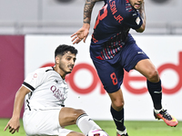 Abdulla Badr Alyazidi (L) of Al-Sadd SC battles for the ball with Edmilson Junior Paulo (R) of Duhail SC during the Ooredoo Qatar Stars Leag...