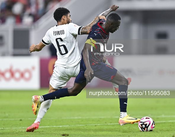 Paulo Silva (L) of Al-Sadd SC battles for the ball with Almoez Abdulla (R) of Duhail SC during the Ooredoo Qatar Stars League 24/25 match be...