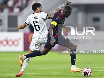 Paulo Silva (L) of Al-Sadd SC battles for the ball with Almoez Abdulla (R) of Duhail SC during the Ooredoo Qatar Stars League 24/25 match be...