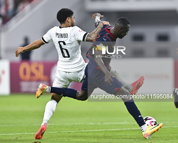 Paulo Silva (L) of Al-Sadd SC battles for the ball with Almoez Abdulla (R) of Duhail SC during the Ooredoo Qatar Stars League 24/25 match be...