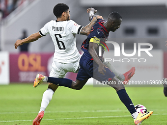 Paulo Silva (L) of Al-Sadd SC battles for the ball with Almoez Abdulla (R) of Duhail SC during the Ooredoo Qatar Stars League 24/25 match be...