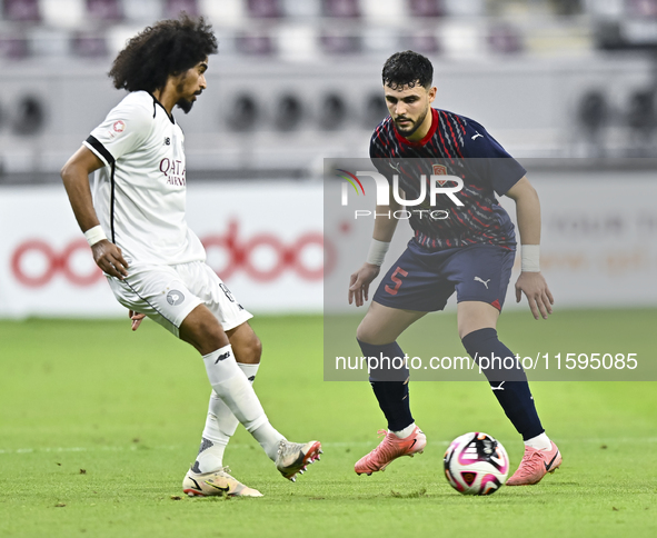 Akram Hassan Afif (L) of Al-Sadd SC battles for the ball with Bassam Hisham (R) of Duhail SC during the Ooredoo Qatar Stars League 24/25 mat...