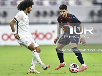 Akram Hassan Afif (L) of Al-Sadd SC battles for the ball with Bassam Hisham (R) of Duhail SC during the Ooredoo Qatar Stars League 24/25 mat...