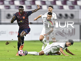 Tarek Salman of Al-Sadd SC battles for the ball with Michael Olunga during the Ooredoo Qatar Stars League 24/25 match between Al-Sadd SC and...