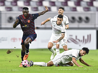 Tarek Salman of Al-Sadd SC battles for the ball with Michael Olunga during the Ooredoo Qatar Stars League 24/25 match between Al-Sadd SC and...