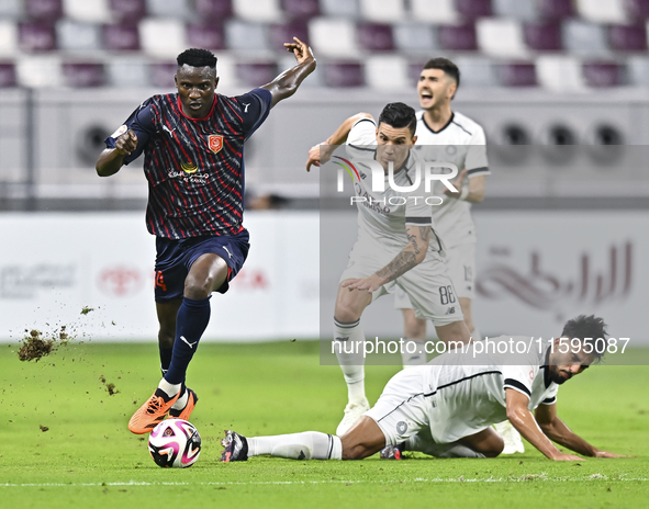 Tarek Salman of Al-Sadd SC battles for the ball with Michael Olunga during the Ooredoo Qatar Stars League 24/25 match between Al-Sadd SC and...