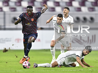 Tarek Salman of Al-Sadd SC battles for the ball with Michael Olunga during the Ooredoo Qatar Stars League 24/25 match between Al-Sadd SC and...