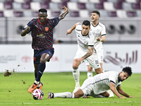 Tarek Salman of Al-Sadd SC battles for the ball with Michael Olunga during the Ooredoo Qatar Stars League 24/25 match between Al-Sadd SC and...