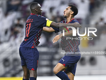 Homam El Amin (R) of Al Duhail SC celebrates after scoring a goal during the Ooredoo Qatar Stars League 24/25 match between Al-Sadd SC and A...