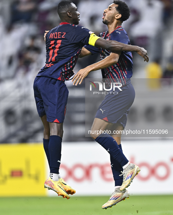 Homam El Amin (R) of Al Duhail SC celebrates after scoring a goal during the Ooredoo Qatar Stars League 24/25 match between Al-Sadd SC and A...