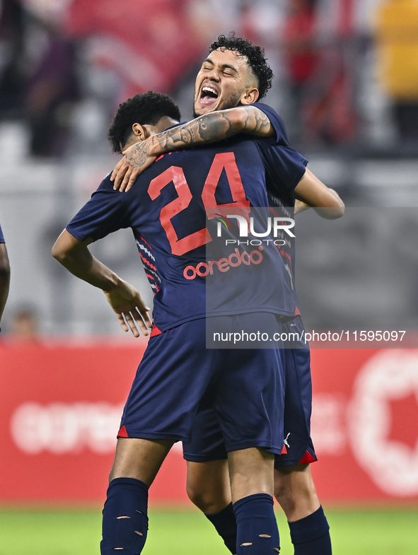 Edmilson Junior Paulo (R) of Al Duhail SC celebrates after scoring the second goal during the Ooredoo Qatar Stars League 24/25 match between...