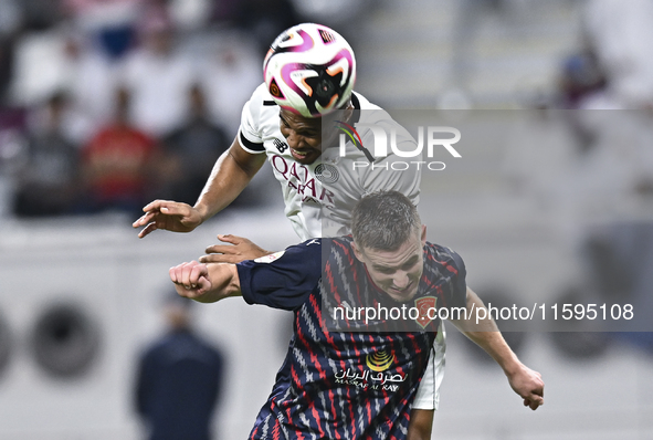 Pedro Miguel Correia (L) of Al-Sadd SC battles for the ball with Benjamin Bourigeaud (R) of Duhail SC during the Ooredoo Qatar Stars League...