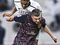 Pedro Miguel Correia (L) of Al-Sadd SC battles for the ball with Benjamin Bourigeaud (R) of Duhail SC during the Ooredoo Qatar Stars League...